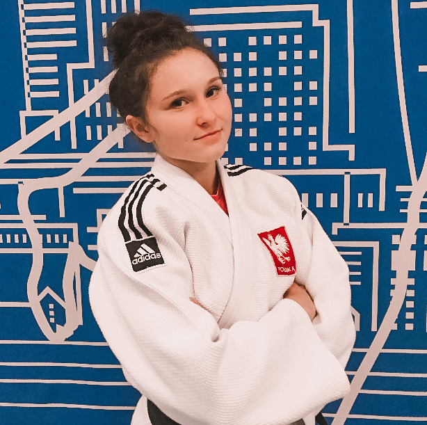 Trener Aleksandra Janeczko w judodze z godłem Polski.